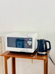 a microwave and a coffee pot on a table at SUBAKO（yado＆community space） in Yurihonjo