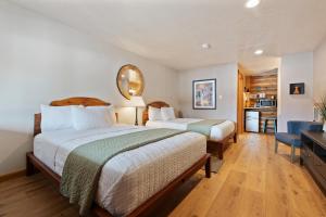 a bedroom with two beds and a mirror on the wall at Duck Creek Village Inn in Duck Creek Village