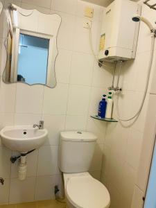 La salle de bains blanche est pourvue de toilettes et d'un lavabo. dans l'établissement Johnson Hostel, à Hong Kong
