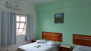 1 dormitorio con 2 camas y ventana en PLAZA HOTEL MARABÁ, en Marabá