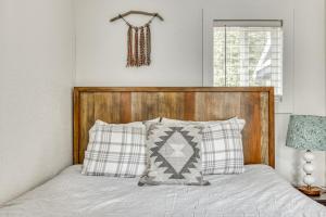 Cama con cabecero de madera y almohadas en Pet-Friendly Riverfront Cabin with Hot Tub & BBQ - Riverbend 2, en Rhododendron