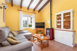 - un salon avec un canapé et une télévision dans l'établissement Villa Nuria Bosch, à Cala'n Bosch