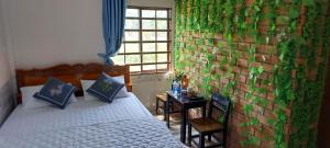 a bedroom with a bed and a wall covered in plants at Cần Thơ Farmstay in Can Tho