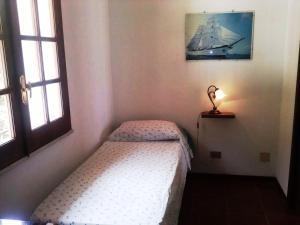 a small bedroom with a bed and a ship on the wall at Villa Fontana in Tropea