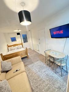 a living room with a couch and a table and a bed at Stevenage Studios - Master Suite in Stevenage