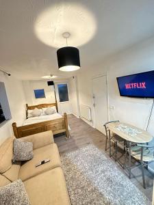 a living room with a couch and a bed at Stevenage Studios - Master Suite in Stevenage