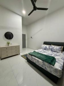 Schlafzimmer mit einem Bett und einem Deckenventilator in der Unterkunft Manis Homestay in Kuala Terengganu