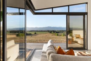 a living room with a couch and a large glass window at Tiffin Hill in Parkvale