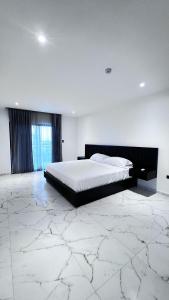 MantaSurf Hotel في Tarqui: غرفة نوم بسرير كبير وأرضية من الرخام