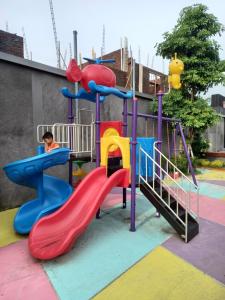 a child playing on a slide at a playground at BELLA NINE EXCLUSIVE HOMESTAY in Sukoharjo