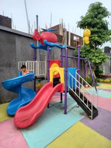 un niño jugando en un tobogán en un parque infantil en BELLA NINE EXCLUSIVE HOMESTAY en Sukoharjo