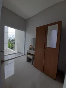 a room with a large window and a wooden cabinet at BELLA NINE EXCLUSIVE HOMESTAY in Sukoharjo