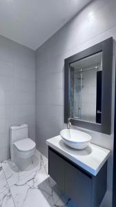 een witte badkamer met een wastafel en een toilet bij MantaSurf Hotel in Tarqui