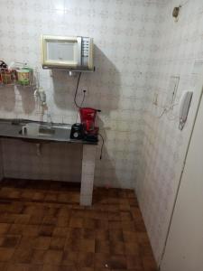 a small kitchen with a sink and a microwave at Condomínio Verdes Mares in Aracaju