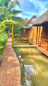 basen z wodą przed niektórymi budynkami w obiekcie Tây Đô Homestay Cần Thơ w mieście Cái Răng