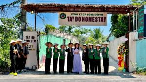 um grupo de crianças posando para uma foto sob um sinal em Tây Đô Homestay Cần Thơ em Cái Răng