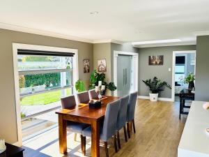 a dining room with a wooden table and chairs at Business or Holiday 4 bedrooms house in Hamilton with pool and spa in Hamilton