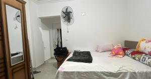 1 dormitorio con 1 cama y ventilador en la pared en New Chalet Sea & Pool view Ras Sedr شاليه جديد دور ارضي في راس سدر, en Ras Sedr