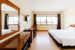 Habitación de hotel con cama y espejo en River Hotel - The Outstanding Venues Nakhon Pathom 