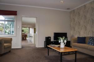 ein Wohnzimmer mit einem Sofa und einem Couchtisch in der Unterkunft Relax On Richmond Modern Large Beach House in New Plymouth