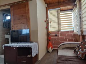 uma sala de estar com televisão numa mesa num quarto em Cabaña para vacacionar em Píllaro