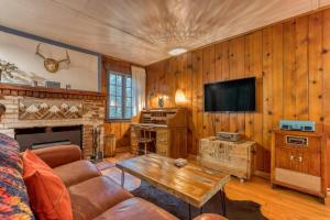sala de estar con sofá, TV y mesa en Springbrook · Cozy 2BR Mt. Hood Cabin, Fireplace & Retro Kitchen, en Mount Hood Village