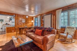 un soggiorno con un divano in pelle e un tavolo di Springbrook · Cozy 2BR Mt. Hood Cabin, Fireplace & Retro Kitchen a Mount Hood Village Altre 47 foto