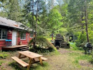 un tavolo da picnic davanti a una casa rossa di Springbrook · Cozy 2BR Mt. Hood Cabin, Fireplace & Retro Kitchen a Mount Hood Village