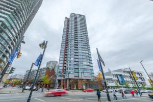 a tall building on a city street with cars at Sub-Penthouse Apartment with Jacuzzi Pool & Sauna in Vancouver
