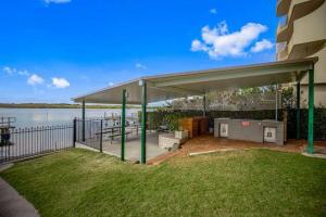 a pavilion on the side of a building next to the water at Maroochydore Riverfront Apartment in Maroochydore