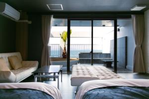 松山的住宿－瀬戸内リゾートホテル，客房设有两张床、一张沙发和一个窗口。