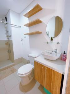 uma casa de banho com um WC, um lavatório e um espelho. em Eco Suite em Trece Martires