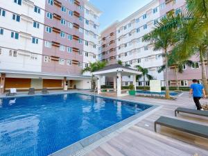 Ein Mann geht an einem Pool vor einem Gebäude vorbei. in der Unterkunft Eco Suite in Trece Martires + 7 Fotos