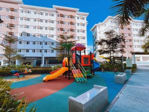 einen Spielplatz vor einem großen Gebäude in der Unterkunft Eco Suite in Trece Martires
