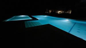 una piscina iluminada por la noche en New Chalet Sea & Pool view Ras Sedr شاليه جديد دور ارضي في راس سدر, en Ras Sedr