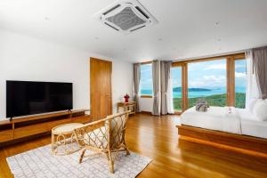 a bedroom with a bed and a flat screen tv at Villa Bella Vista Samui - 360 Degrees Mountain View in Taling Ngam Beach