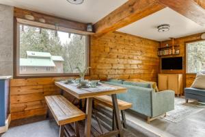 sala de estar con paredes de madera, mesa y sillas en Thompson Cabin - Charming Salmon Riverfront A-Frame Oasis w/ fireplace, en Welches