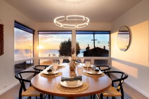 a dining room with a table and chairs and a large window at Sunset Serenity On The Cliffs! in San Diego