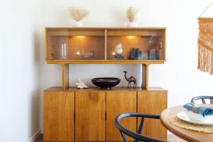 a wooden cabinet in a dining room with a table at Sunset Serenity On The Cliffs! in San Diego