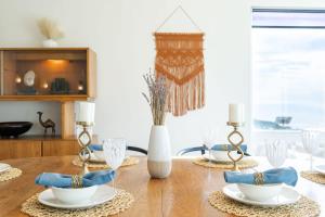 a dining room table with glasses and a vase at Sunset Serenity On The Cliffs! in San Diego