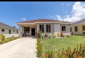 a house with a lawn in front of it at Luxury Palm in Old Harbour