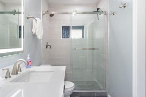 a bathroom with a shower with a toilet and a sink at Sunset Serenity On The Cliffs! in San Diego