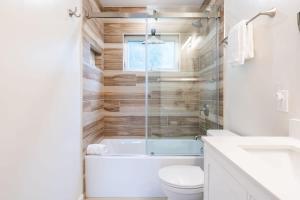 a bathroom with a tub and a toilet and a sink at Sunset Serenity On The Cliffs! in San Diego