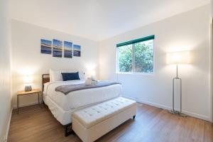 a white bedroom with a bed and a window at Sunset Serenity On The Cliffs! in San Diego