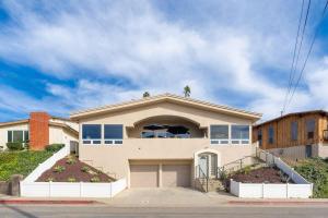 a house with two palm trees on top of it at Sunset Serenity On The Cliffs! in San Diego