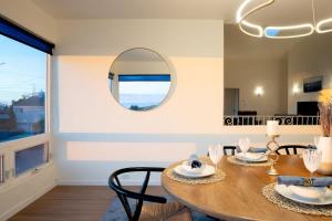 a dining room with a table and a mirror at Sunset Serenity On The Cliffs! in San Diego