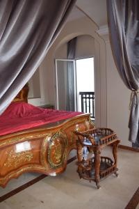 1 dormitorio con cama de madera, mesa y ventana en Marina Agadir Royal Apartment, en Agadir