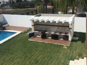 a barbecue grill in a yard next to a pool at Residencia en Oaxtepec in Oaxtepec