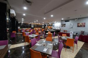 a restaurant with purple tables and purple chairs at HORU HOTEL MANGGA DUA SQUARE in Jakarta