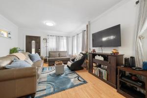 un soggiorno con divano e TV a schermo piatto di Comfy and Convenient Room in NY a Jamaica